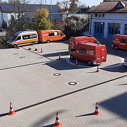 Vorne die Vorfahrt zur Probensammelstelle (PSST) und getrennt im hinteren Bereich die Messleitung auf dem Hof der Feuerwehr Aschheim. Rechts die "Wagenburg" zur gemeinsamen Stationsausbildung zu den Messaufträgen und Probenahme-Techniken